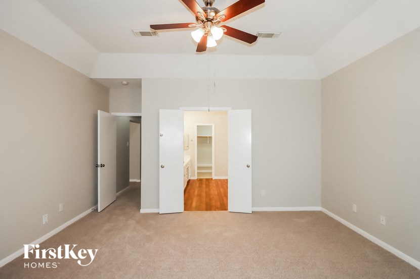 a empty living room with a ceiling fan