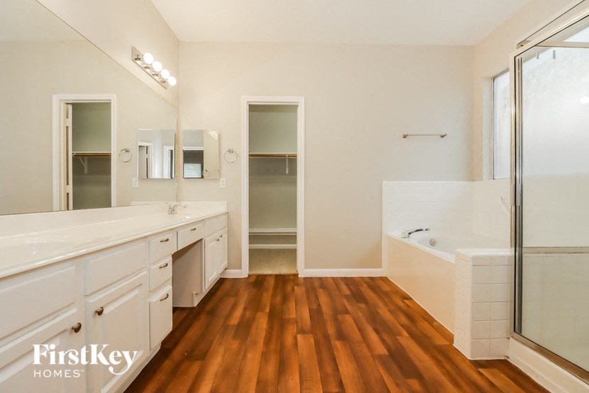 a large bathroom with a tub and a sink and a shower