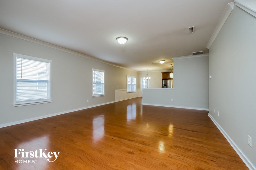 an empty living room with wood floors and white walls