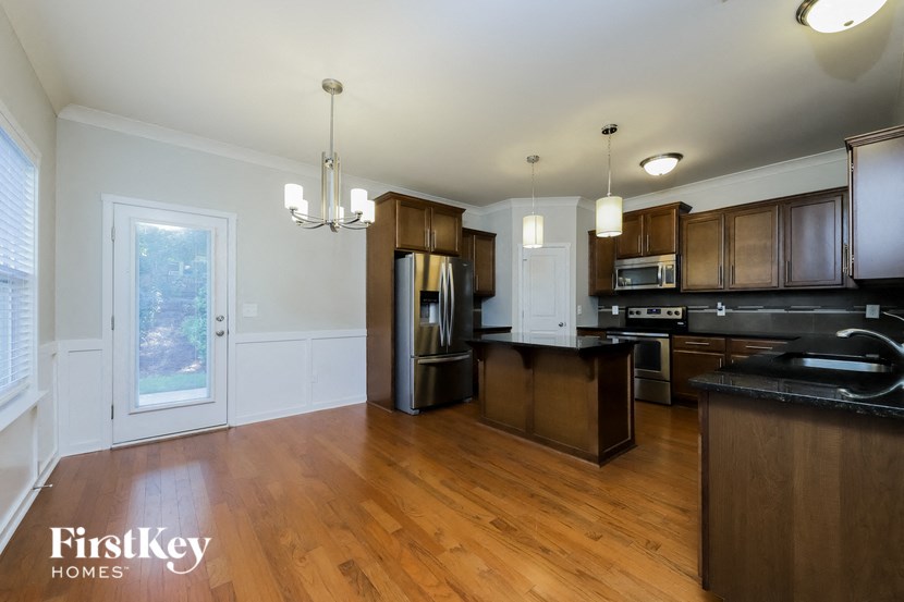 a kitchen with wooden floors and stainless steel appliances