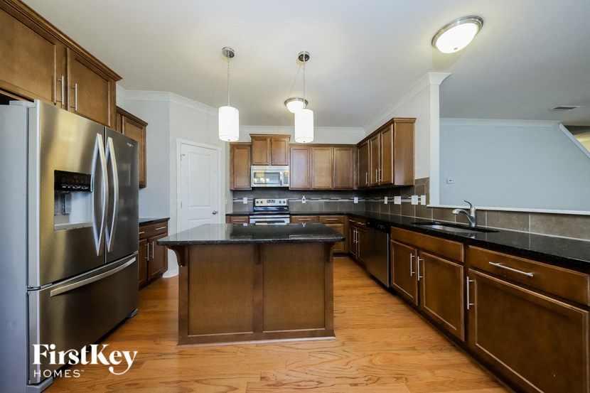 a large kitchen with stainless steel appliances and black counter tops