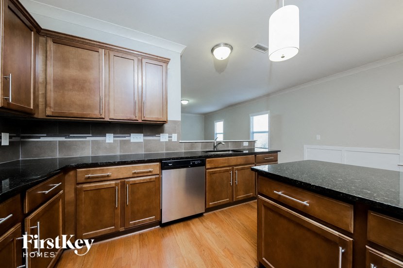 a kitchen with wooden cabinets and black counter tops