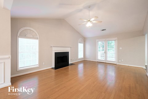 A spacious room with a fireplace and a ceiling fan.