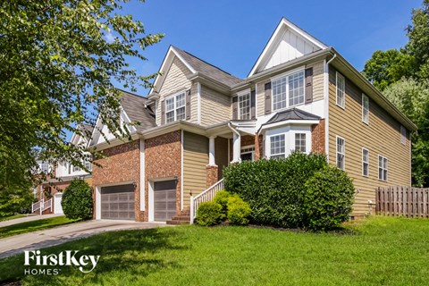 the front of a house with green grass and a sidewalk