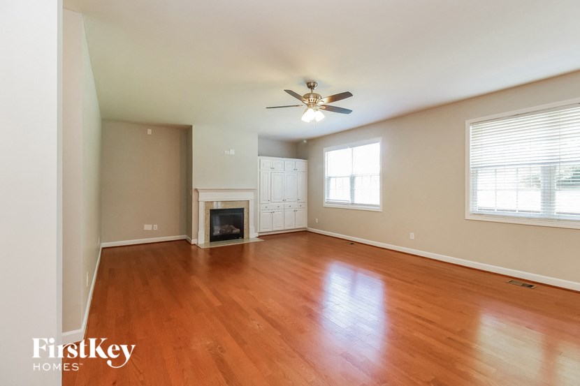an empty living room with wood floors and a fireplace