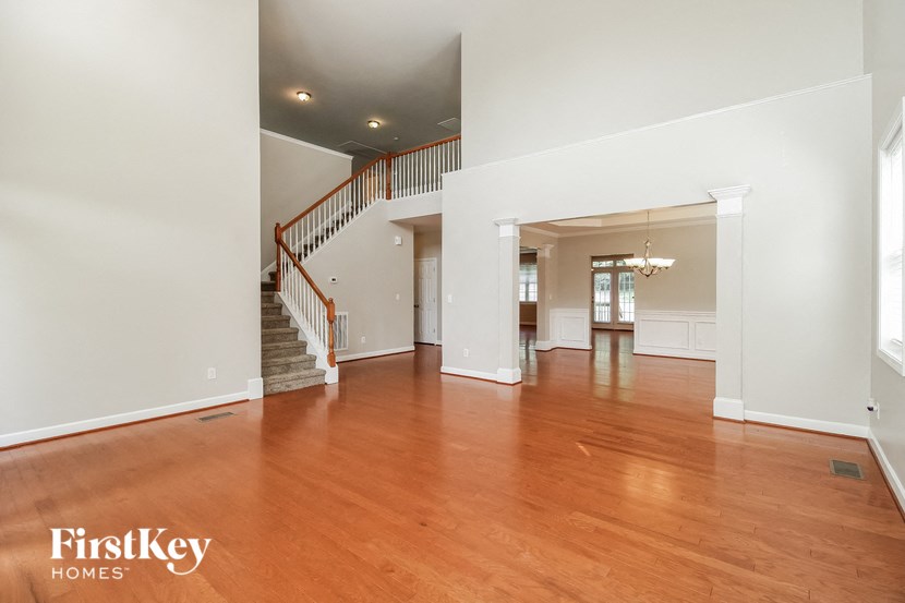 a large living room with wood floors and a staircase