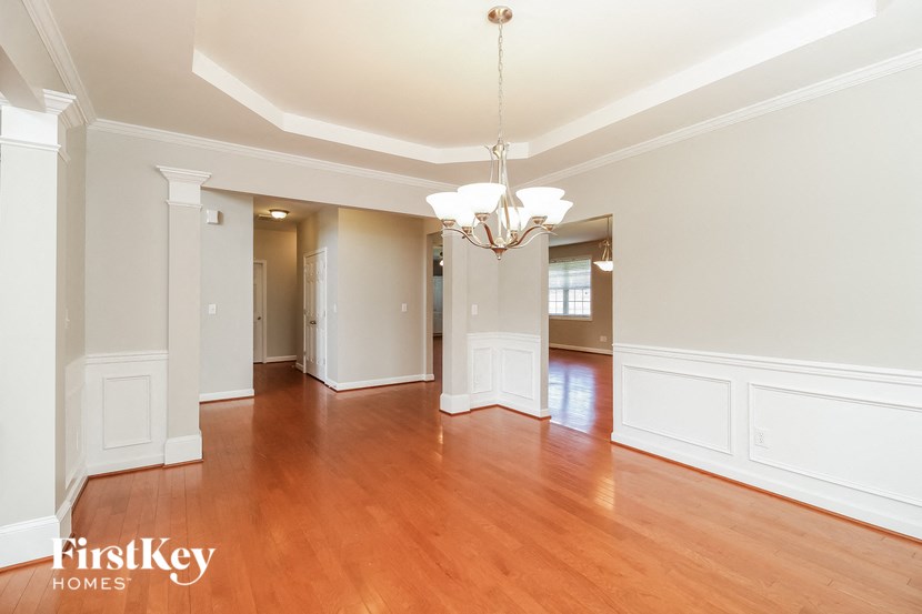 an empty living room with white walls and wood floors
