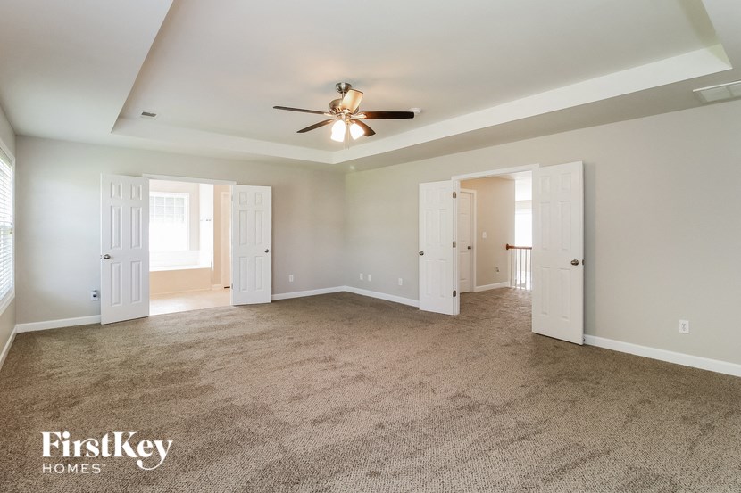 a living room with carpet and a ceiling fan