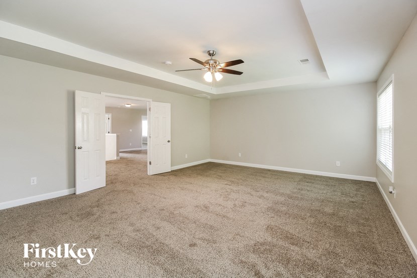 a living room with carpet and a ceiling fan