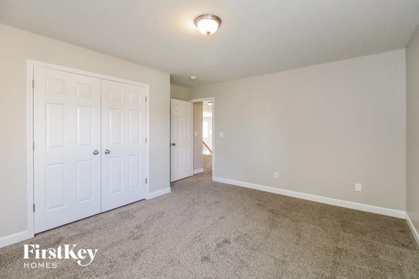 a bedroom with two closets and a carpeted floor