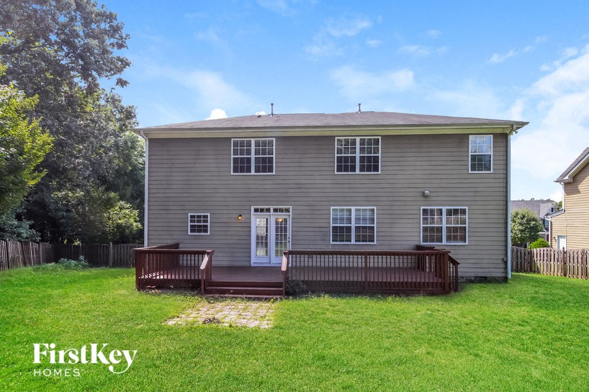 the back of a house with a porch and a wooden deck