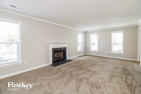 the living room has a fireplace and carpeted flooring