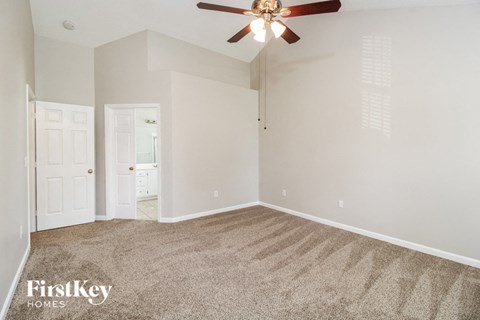 a bedroom with carpet and a ceiling fan