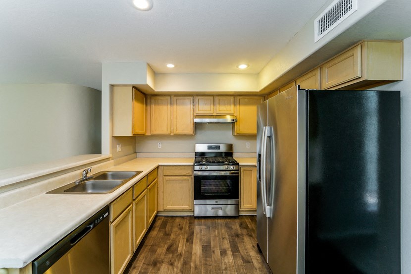 a kitchen with wooden cabinets and stainless steel appliances