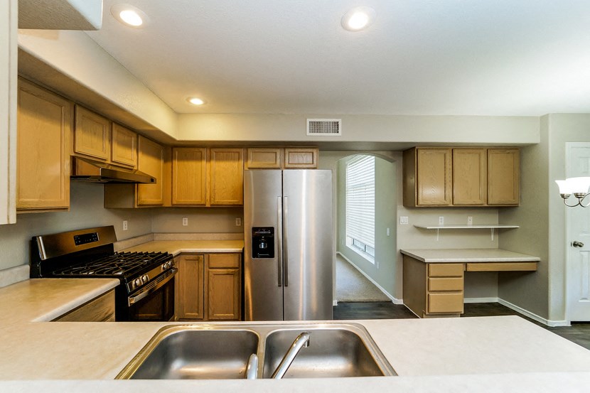 a kitchen with stainless steel appliances and wooden cabinets