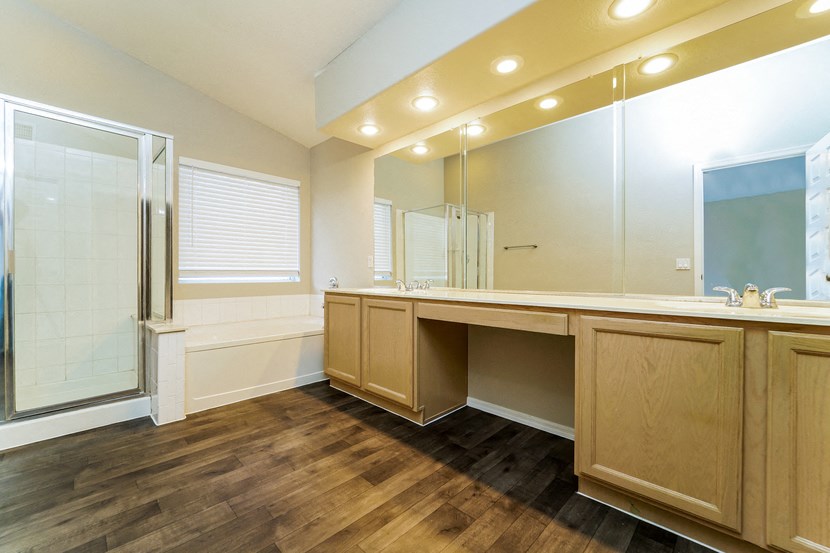 a bathroom with a large mirror and a sink and a shower