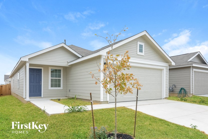 a gray house with a blue door and a lawn