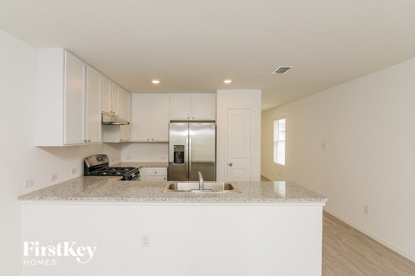 a kitchen with white cabinets and a granite counter top