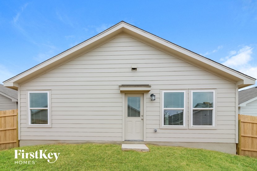 the exterior of a white house with a white front door and a lawn