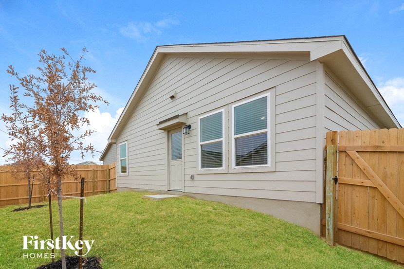 the exterior of a home with a wooden fence and grass