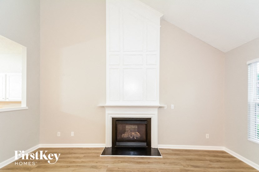 a living room with a fireplace and a white wall