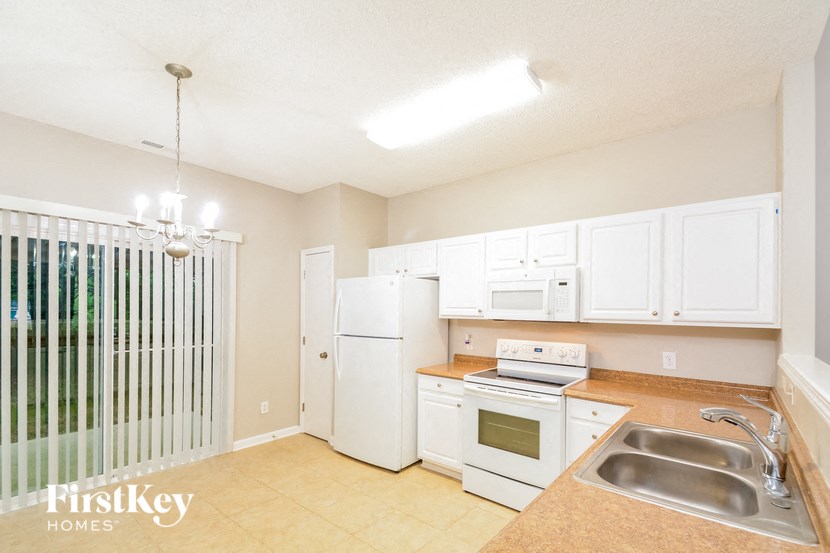 a kitchen with white appliances and white cabinets
