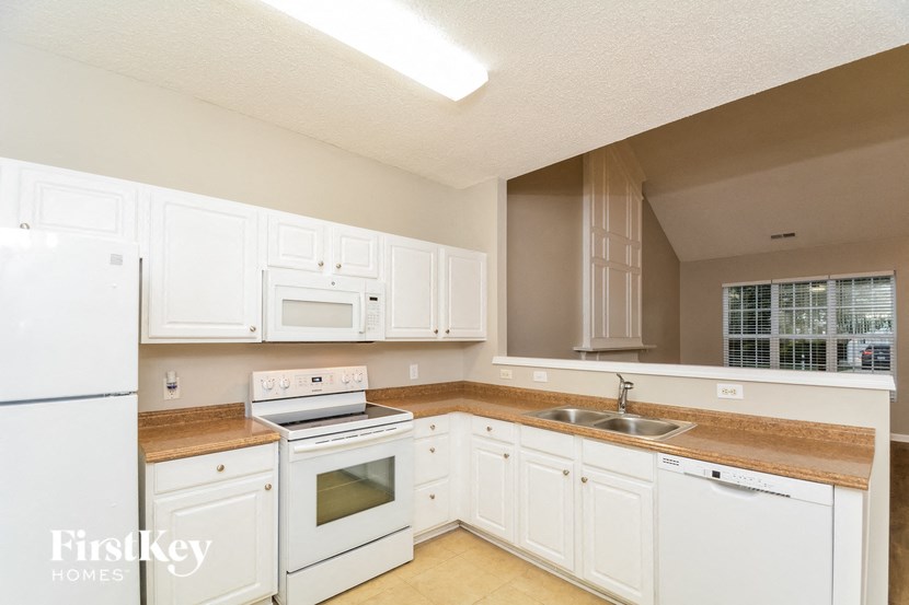 a white kitchen with white appliances and white cabinets