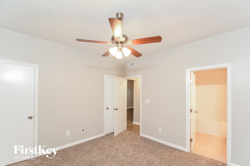 a bedroom with a ceiling fan and a door to a closet