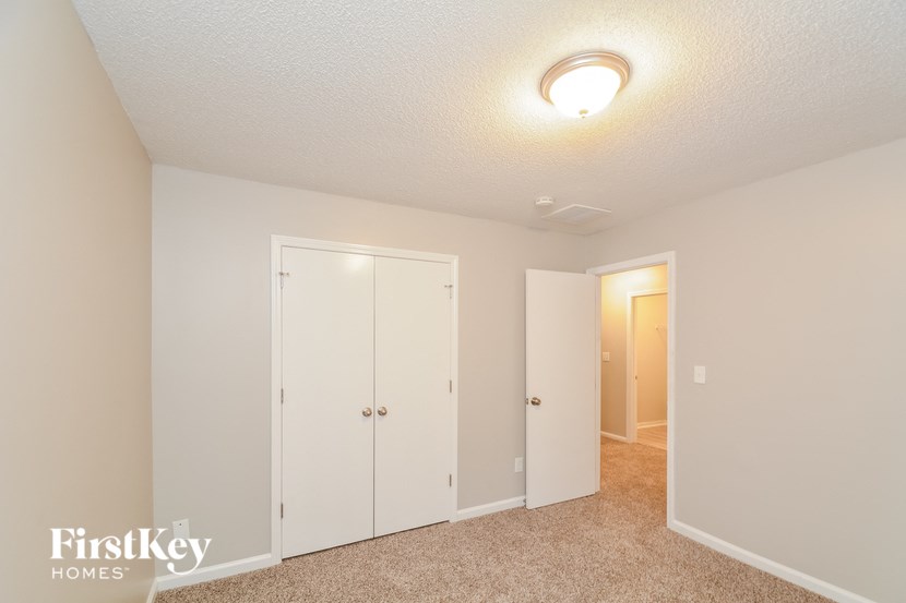 a bedroom with a closet and a door to a hallway