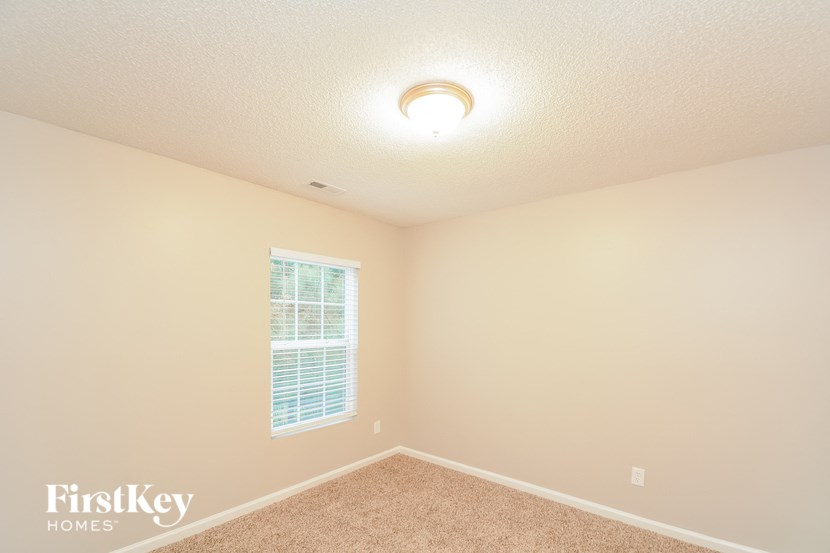 an empty room with a window and a light on the ceiling