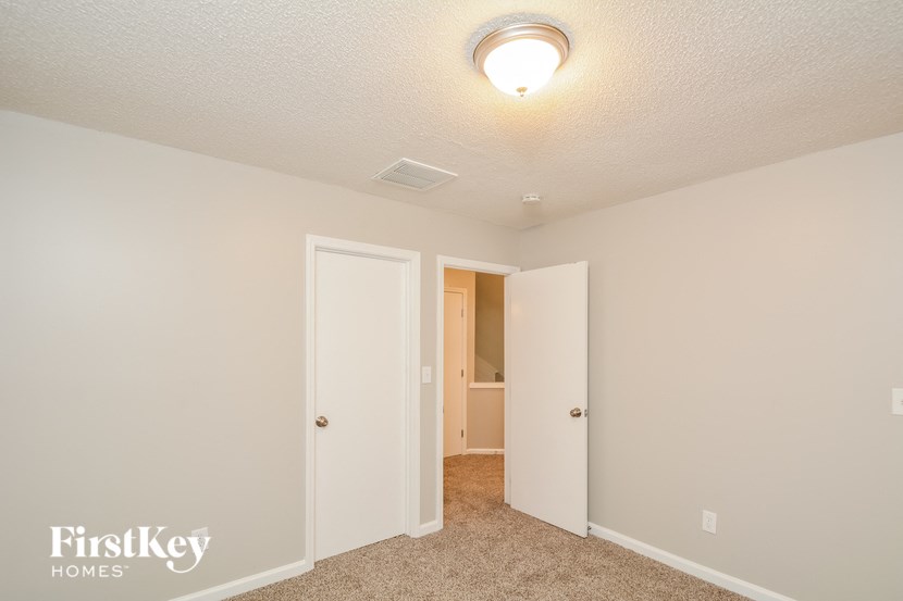 a bedroom with a closet and a door to a bathroom