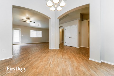 the living room and dining room with wood flooring and a ceiling fan