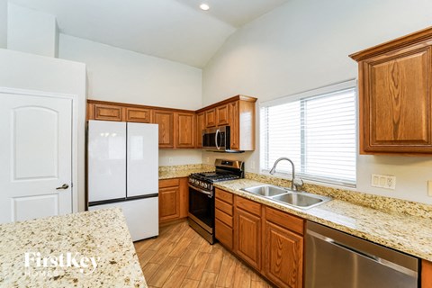 an updated kitchen with granite counter tops and wooden cabinets