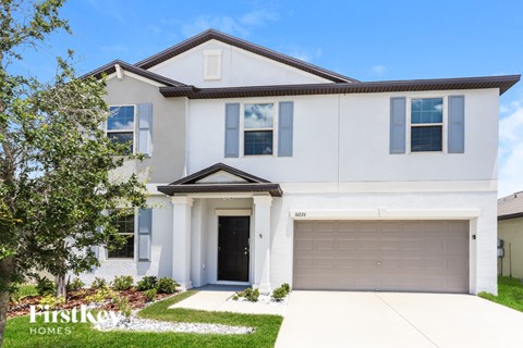 A two-story house with a garage is for sale.