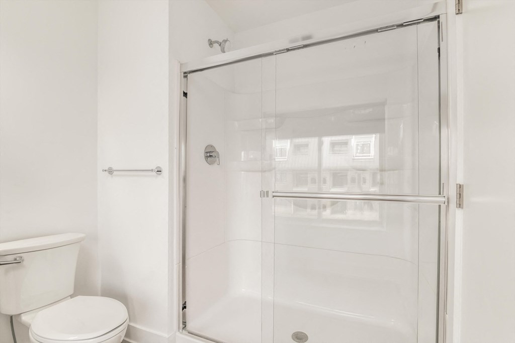 a white bathroom with a shower and a toilet