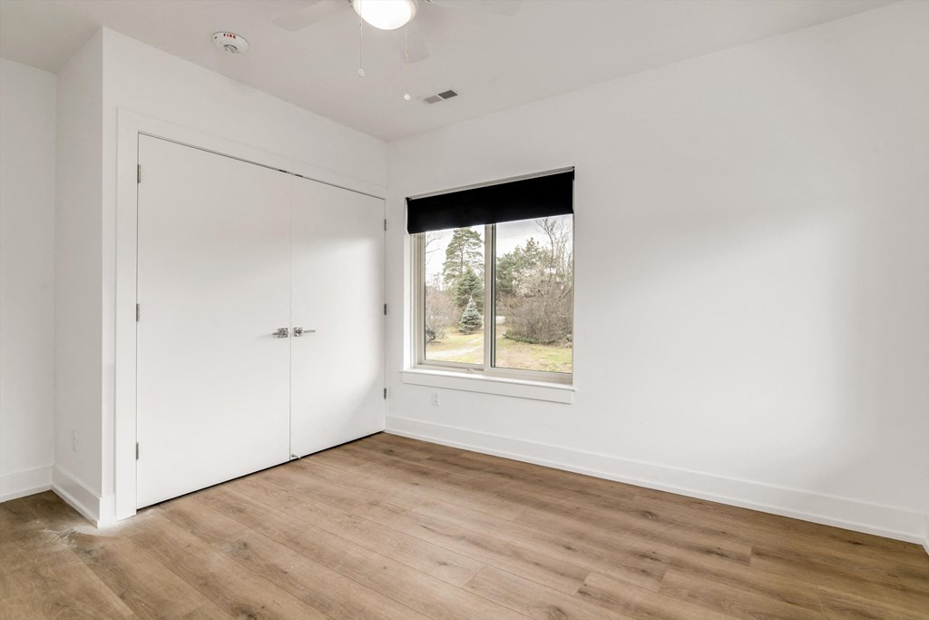 a bedroom with white walls and a window and a door