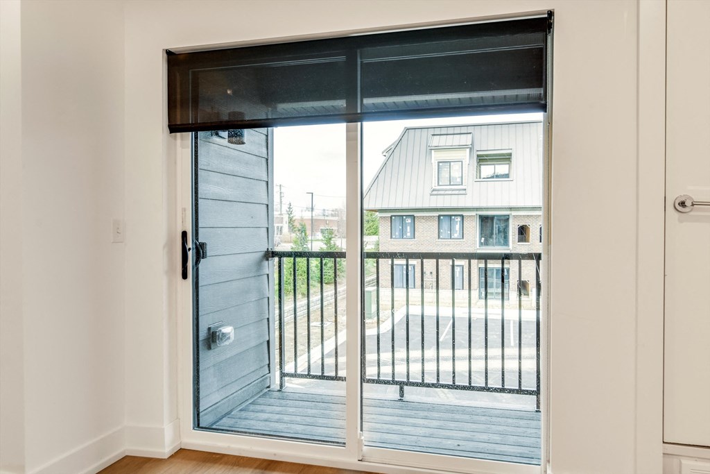 a sliding glass door with a view of a balcony and a house