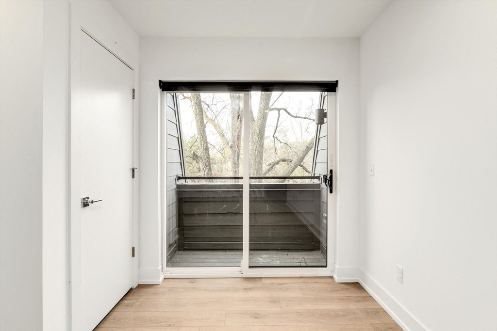 a room with a large window and a door to a deck