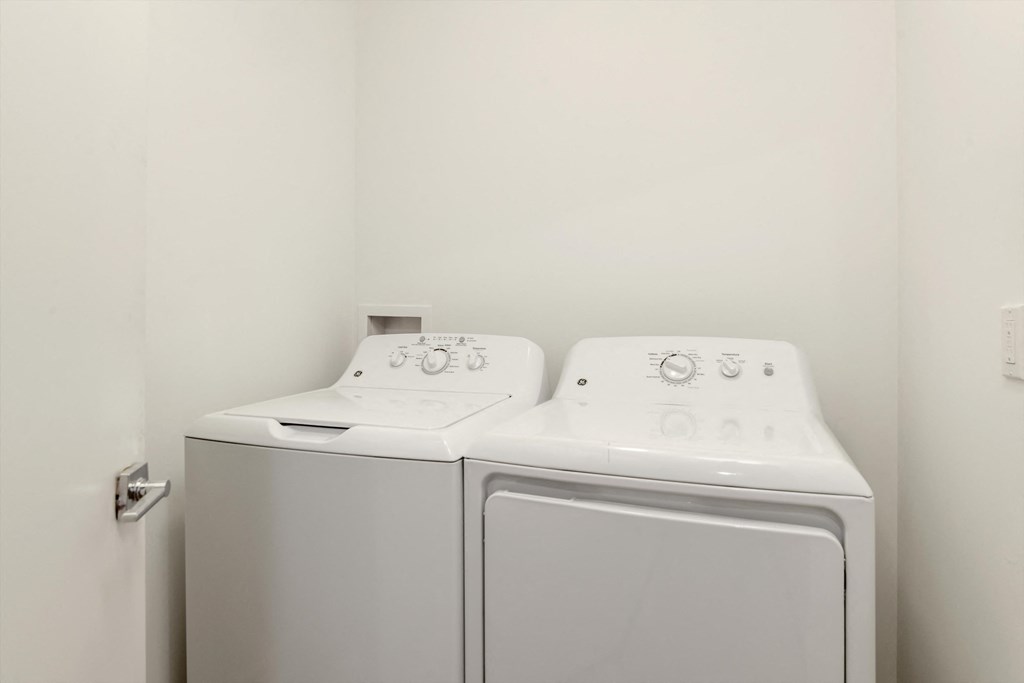 a washer and dryer in a room with a white wall and a door