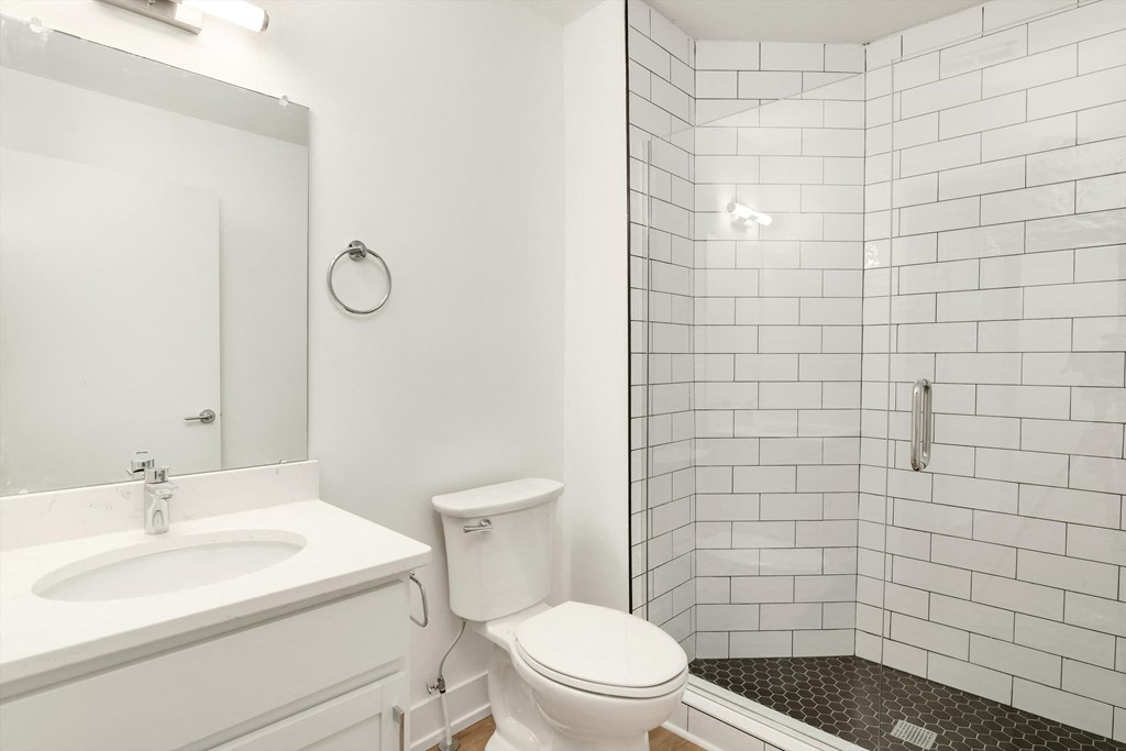 a white bathroom with a toilet sink and shower
