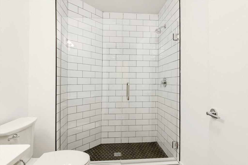 a white tiled shower in a white bathroom