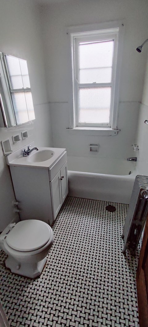 a bathroom with a toilet and a sink and a window