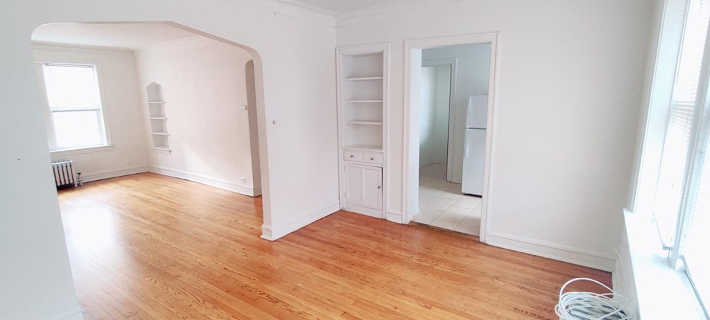 an empty living room with white walls and wood floors