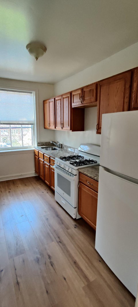 a kitchen with white appliances and wooden cabinets