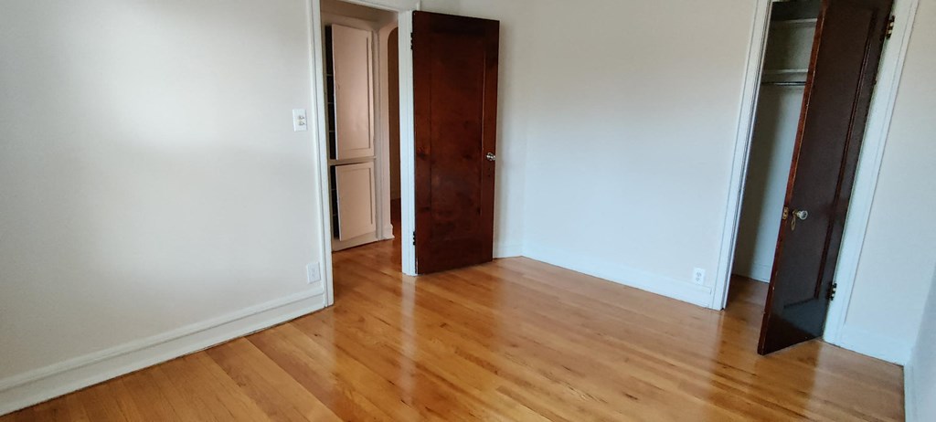 a living room with a wooden floor and a closet