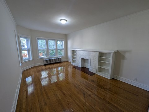 A room with a fireplace and wooden floors.