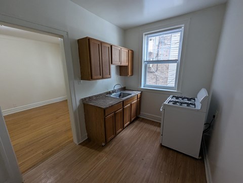 A kitchen with wooden floors and white walls.