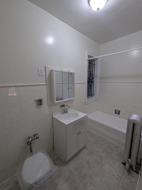 A white bathroom with a toilet, sink, and bathtub.