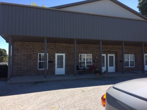 the front of a brick building with a porch