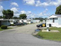 a group of trailers and cars parked in a parking lot
